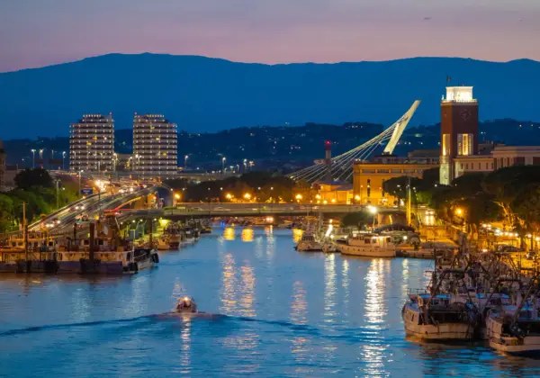 Wieczorem w Pescara: port z Åodziami, nowoczesne budynki, most i wieÅ¼a zegarowa. Warto zobaczyÄ!